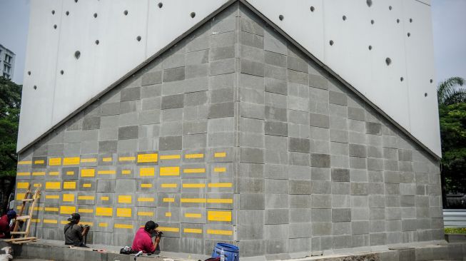 Pekerja memahat nama dari tenaga kesehatan yang gugur akibat COVID-19 di Monumen Gasibu, Bandung, Jawa Barat, Senin (4/10/2021).  ANTARA FOTO/Raisan Al Farisi