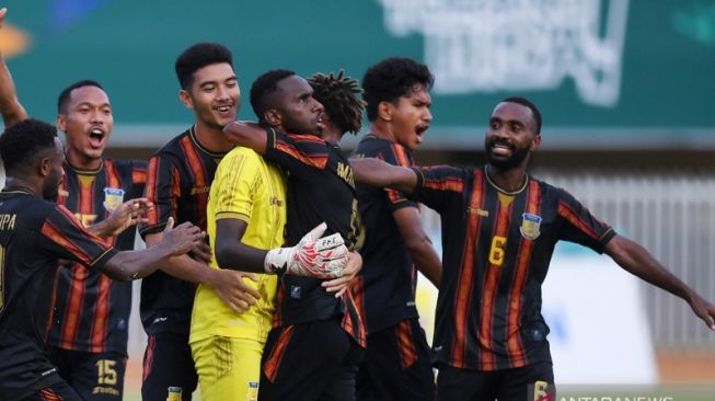 Penjaga gawang Jhon Rericnal Pigai (tengah) disambut rekannya usai mencetak gol ke gawang Nusa Tenggara Timur melalui tendangan bebas saat bertanding pada pertandingan penyisihan Sepak Bola Putra PON Papua di Stadion Mandala, Kota Jayapura, Papua, Minggu (3/10/2021). Pada pertandingan tersebut tuan rumah Papua menang atas Nusa Tenggara Timur dengan skor 4-0. ANTARA FOTO/Mohammad Ayudha/hp.