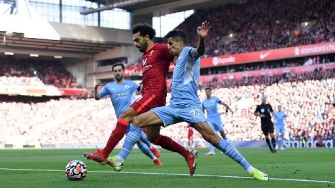 Pemain Liverpool Mohamed Salah (tengah) ditempel bek Manchester City Joao Cancelo selama pertandingan sepak bola Liga Premier Inggris di Anfield di Liverpool pada 3 Oktober 2021.Paul ELLIS / AFP