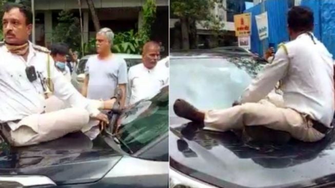 Polisi nekat duduk di atas kap mesin mobil gara-gara pelanggar yang tak mau berhenti (Cartoq)