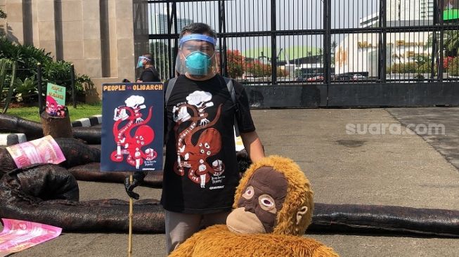 Aktivis Greenpeace berujuk rasa samberi membawa "Monster Oligarki" di depan gedung DPR. (Suara.com/Novian)