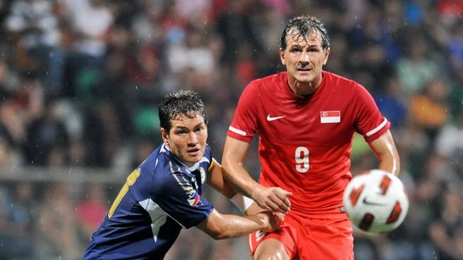 Kapten Filipina, Alexander Borromeo (kiri) berebut bola dengan penyerang Singapura Aleksandar Duric (kanan) selama pertandingan persahabatan internasional di Singapura pada 7 Oktober 2011. AFP FOTO/ROSLAN RAHMAN.