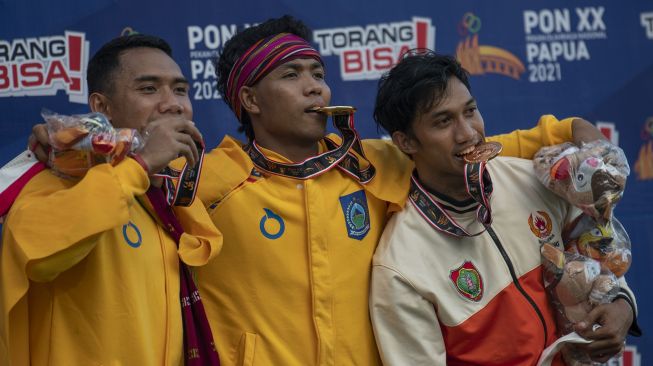 Pelari Nusa Tenggara Barat Lalu Mohammad Zohri (tengah) dan Sudirman Hadi (kiri) serta pelari Kalimantan Tengah Eko Rimbawan berpose usai bertanding dalam final nomor lari 100 meter putra PON Papua di Stadion Atletik Mimika Sport Center, Kabupaten Mimika, Papua, Rabu (6/10/2021).. ANTARA FOTO/Aditya Pradana Putra