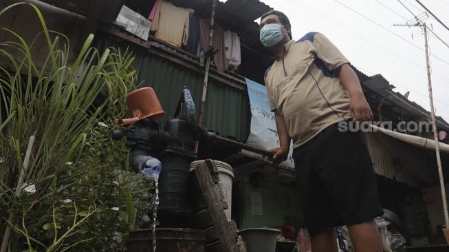 Warga memompa air tanah di kawasan Petamburan, Jakarta, Rabu (6/10/2021). [Suara.com/Angga Budhiyanto]