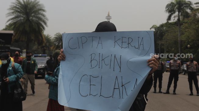 Massa yang tergabung dalam Badan Eksekutif Mahasiswa Seluruh Indonesia (BEM SI) membawa poster saat melakukan aksi simbolik di kawasan Patung Kuda Arjuna Wiwaha, Jakarta, Rabu (6/10/2021). [Suara.com/Angga Budhyanto]