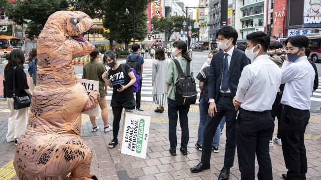 Aktivis kelompok hak hewan PETA melakukan aksi dengan mengenakan kostum Dinosaurus di Tokyo, Jepang, Rabu (6/10). Charly TRIBALLEAU / AFP