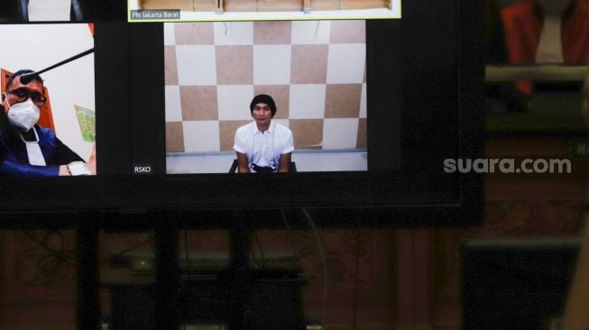 Musisi Erdian Aji Prihartanto atau Anji saat menjalani sidang secara virtual di Pengadilan Negeri Jakart Barat, Rabu (6/10/2021). [Suara.com/Alfian Winanto]