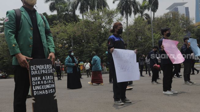 Massa yang tergabung dalam Badan Eksekutif Mahasiswa Seluruh Indonesia (BEM SI) melakukan aksi simbolik di kawasan Patung Kuda Arjuna Wiwaha, Jakarta, Rabu (6/10/2021). [Suara.com/Angga Budhiyanto]