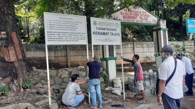 Sejumlah petugas memasang plang Keramat Tajug sebagai cagar budaya di Serpong, Kota Tangerang Selatan (Tangsel) pada Rabu (6/10/2021). [SuaraJakarta.id/Wivy Hikmatullah]