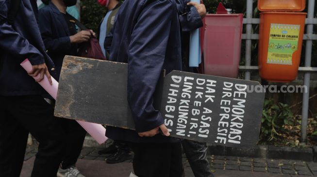 Massa yang tergabung dalam Badan Eksekutif Mahasiswa Seluruh Indonesia (BEM SI) membawa nisan bertuliskan tuntutan usai melakukan aksi simbolik di kawasan Patung Kuda Arjuna Wiwaha, Jakarta, Rabu (6/10/2021). [Suara.com/Angga Budhyanto]