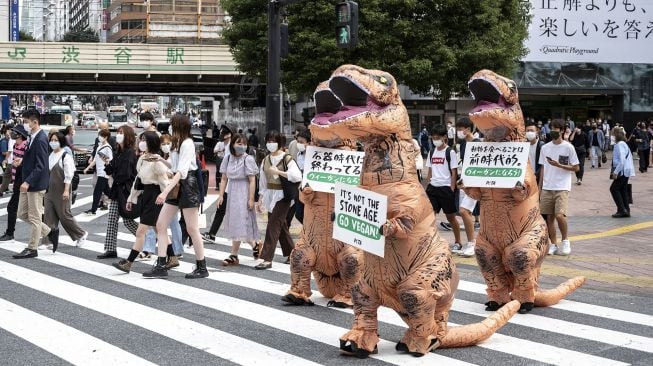 Aktivis kelompok hak hewan PETA melakukan aksi dengan mengenakan kostum Dinosaurus di Tokyo, Jepang, Rabu (6/10). . Charly TRIBALLEAU / AFP