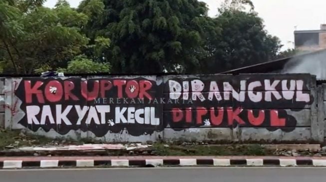 Tangkapan layar video viral grafiti satire bertuliskan Koruptor Dirangkul, Rakyat Kecil Dipukul di Jalan Taman Bintaro Barat, Pesanggrahan, Jakarta Selatan. [Instagram@merekamjakarta]