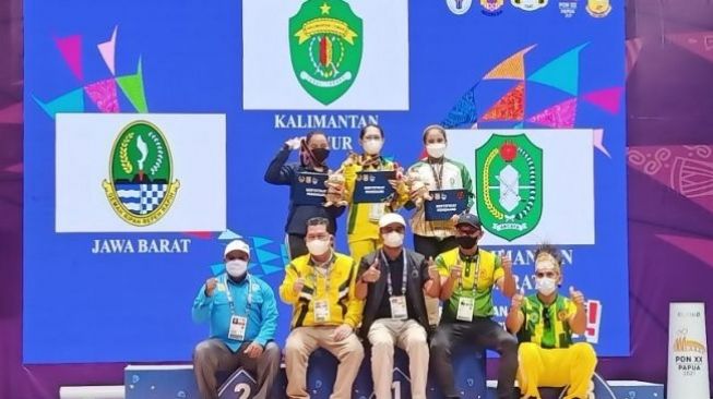 Atlet peraih medali angkat besi putri di kelas 59kg PON XX Papua berpose di podium kemenangan Auditorium Uncen, Kabupaten Jayapura, Papua. [ANTARA]