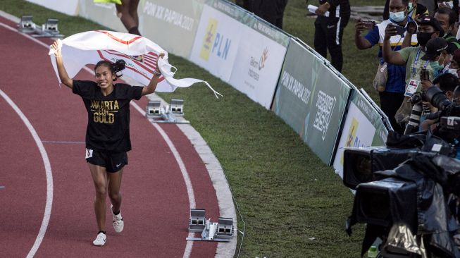 Atlet DKI Jakarta Odekta Elvina Naibaho (kiri) melakukan selebrasi usai menang pada final nomor Lari 10.000 meter Putri PON Papua di Stadion Atletik Mimika Sport Center, Kabupaten Mimika, Papua, Kamis (7/10/2021).  ANTARA FOTO/Novrian Arbi