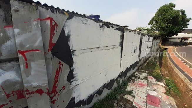 Grafiti satire Koruptor Dirangkul, Rakyat Kecil Dipukul di Jalan Taman Bintaro Barat, Pesanggrahan, Jakarta Selatan, kekinian telah dihapus dengan cat warna putih, Kamis (7/10/2021). [SuaraJakarta.id/Wivy Hikmatullah]