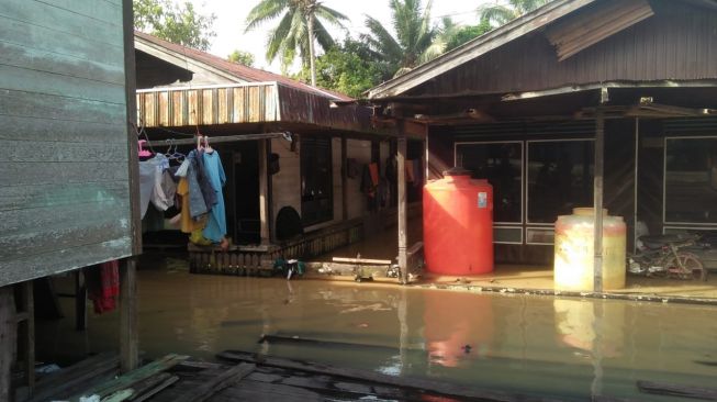 Situasi banjir di Jalan Raya kilometer 64 RT 14, Long Kali. [Suara.com/Denada S Putri]