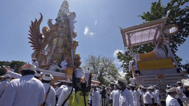 Ratusan warga mengiringi arak-arakan bade atau menara usungan jenazah Ida Pedanda Nabe Gede Dwija Ngenjung saat upacara Ngaben di kawasan Sanur, Denpasar, Bali, Jumat (8/10/2021). [ANTARA FOTO/Nyoman Hendra Wibowo]