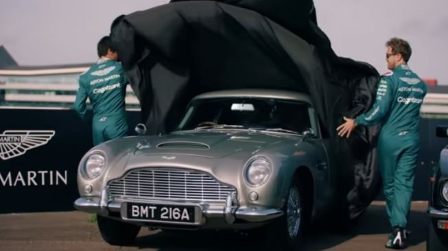 Lance Stroll dan Sebastian Vettel menyingkap cover Aston Martin DB5 [YouTube: Aston Martin].