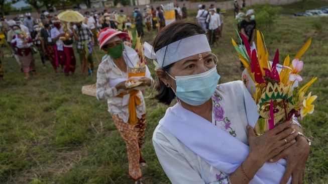 Umat Hindu membawa "Upakara" atau persembahan usai mengikuti ritual Ngulapin (pembangkitan roh) pada upacara Ngaben Ngerit di Pura Prajapati, Palu, Sulawesi Tengah, Kamis (7/10/2021). [ANTARA FOTO/Basri Marzuki]