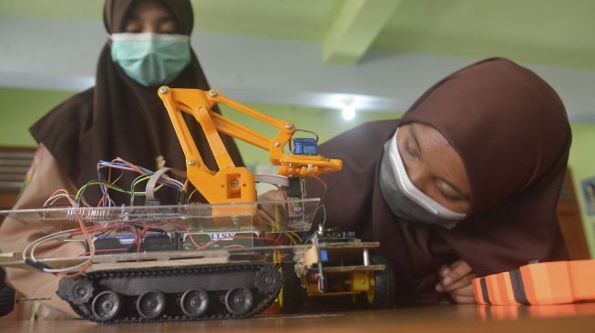 Siswa memasang komponen pada mobil robot sebelum diujicobakan di Sekolah Madrasah Tsanawiyah Negeri-1 (MTsN) Banda Aceh, Aceh, Jumat (8/10/2021). [ANTARA FOTO/Ampelsa]