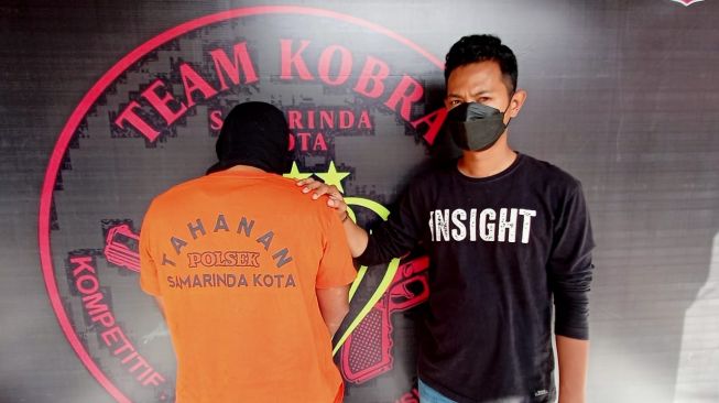 Pelaku Ilman alias Ila hanya bisa membelakangi wartawan sembari tertunduk. Ila diamankan oleh Tim Cobra Polsek Samarinda Kota. [Suara.com/Apriskian Tauda Parulian]