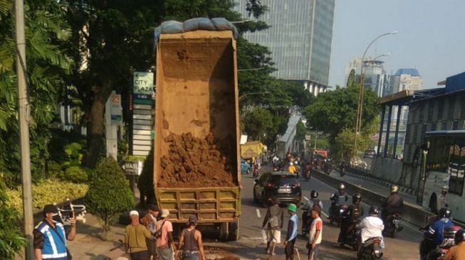 Truk Tabrak Separator hingga Terguling di Gatot Subroto, Tanah yang Dibawa Tumpah ke Jalan