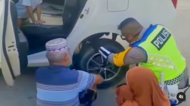 Aksi heroik polisi membantu pengendara mobil ganti ban pecah viral di media sosial (Instagram)