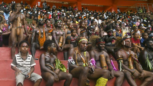 Warga menyaksikan pertandingan tim sepak bola putri Papua melawan tim sepak bola putri Babel pada semifinal Sepak Bola Putri PON Papua di Stadion Katalpal, Kabupaten Merauke, Papua, Sabtu (9/10/2021). [ANTARA FOTO/Galih Pradipta]