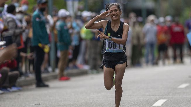 Atlet DKI Jakarta Odekta Elvina Naibaho berselebrasi usai mencapai garis finish dalam nomor lari maraton putrI PON Papua di kompleks Freeport, Kuala Kencana, Kabupaten Mimika, Papua, Sabtu (9/10/2021). [ANTARA FOTO/Aditya Pradana Putra]