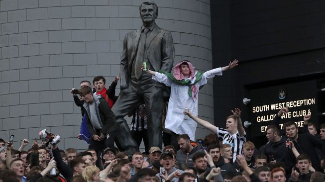 Pendukung Newcastle United melakukan selebrasi di luar stadion klub St James 'Park, Newcastle upon Tyne, Inggris, pada (7/10/2021). [AFP]