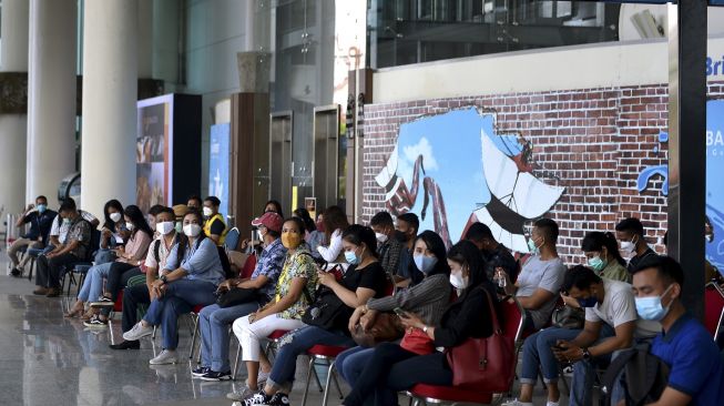 Peserta antre di 'holding area' sebelum menuju hotel karantina saat simulasi penerbangan internasional di Bandara Internasional I Gusti Ngurah Rai, Badung, Bali, Sabtu (9/10/2021). [ANTARA FOTO/Fikri Yusuf]