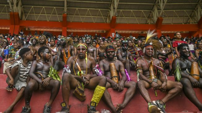 Warga menyaksikan pertandingan tim sepak bola putri Papua melawan tim sepak bola putri Babel pada semifinal Sepak Bola Putri PON Papua di Stadion Katalpal, Kabupaten Merauke, Papua, Sabtu (9/10/2021). [ANTARA FOTO/Galih Pradipta]