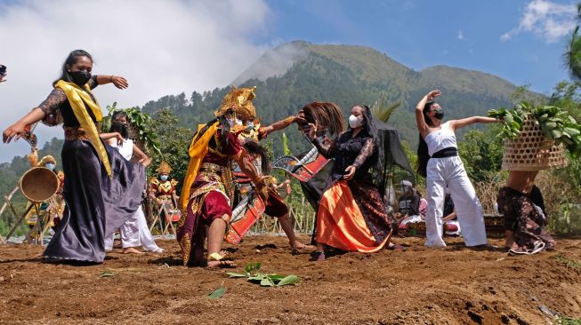 Sejumlah penari anggota komunitas lima gunung menampilkan kolaborasi tari Peradaban Desa saat Festival Lima Gunung (FLG) XX sesi lima di tengah perladangan kawasan lereng gunung Andhong Dusun Mantran, Girirejo, Ngablak, Magelang, Jateng, Minggu (10/10/2021). ANTARA FOTO/Anis Efizudin