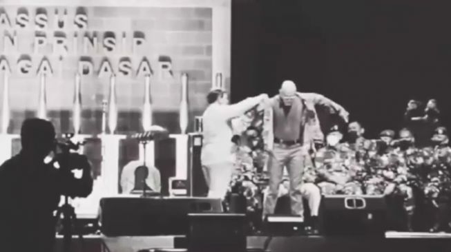 Deddy Corbuzier saat dibantu Prabowo Subianto mengenakan seragam loreng. Deddy pun juga hormat di depan Prabowo Subianto.