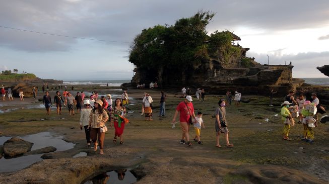 Wisatawan mengunjungi objek wisata Tanah Lot pada pemberlakuan pembatasan kegiatan masyarakat (PPKM) level 3 di Tabanan, Bali, Sabtu (9/10/2021). ANTARA FOTO/Nyoman Hendra Wibowo
