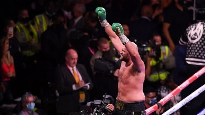 Tyson Fury dari Inggris merayakan kemenangannya atas penantangnya Deontay Wilder dari Amerika Serikat pada ronde ke-11 perebutan gelar Kelas Berat WBC di T-Mobile Arena di Las Vegas, Nevada, 9 Oktober 2021.Robyn Beck / AFP