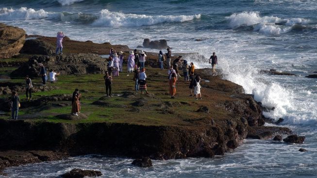 Wisatawan mengunjungi objek wisata Tanah Lot pada pemberlakuan pembatasan kegiatan masyarakat (PPKM) level 3 di Tabanan, Bali, Sabtu (9/10/2021). ANTARA FOTO/Nyoman Hendra Wibowo
