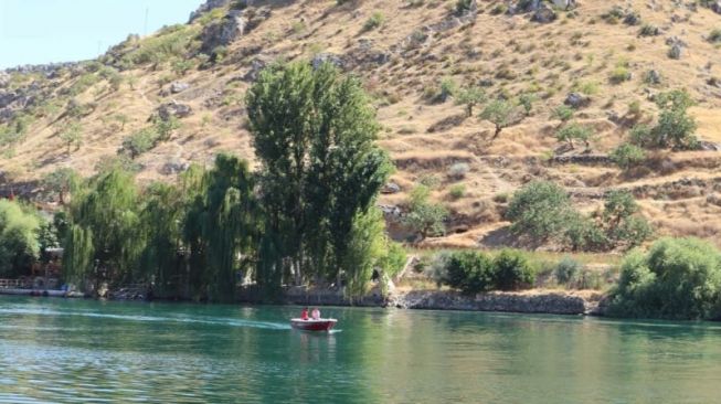 Pengunjung terlihat tengah mengarungi bendungan di Halfeti, Sanliurfa, Turki dengan menggunakan perahu. (ANTARA/Arnidhya Nur Zhafira)