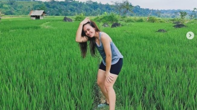 Gaya artis pemotretan di tengah sawah. [Instagram/wulanguritno]