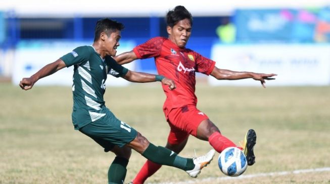 Pesepak bola Jawa Timur Dwi Mardiyanto (kiri) menendang bola dan dihalau pesepak bola Aceh Khairunnas (kanan) pada semifinal Sepak Bola Putra PON Papua di Stadion Barnabas Youwe, Sentani, Kabupaten Jayapura, Papua, Selasa (12/10/2021). ANTARA FOTO/Zabur Karuru/wsj