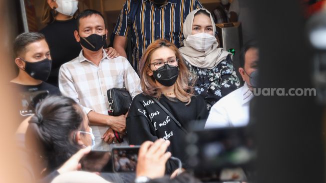 Pedangdut Ayu Ting Ting bersama kedua orang tuanya, Abdul Rozak dan Umi Kalsum usai menjalani pemeriksaan di Polda Metro Jaya, Jakarta Selatan, Selasa (12/11/2021). [Suara.com/Alfian Winanto]