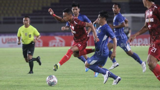 Winger Persis Solo, Rifaldi Bawuo melewati adangan dua pemain PSIM Yogyakarta dalam lanjutan Liga 2 Grup C di Stadion Manahan, Selasa (12/10/2021). [Suara.com/Ronald Seger Prabowo]