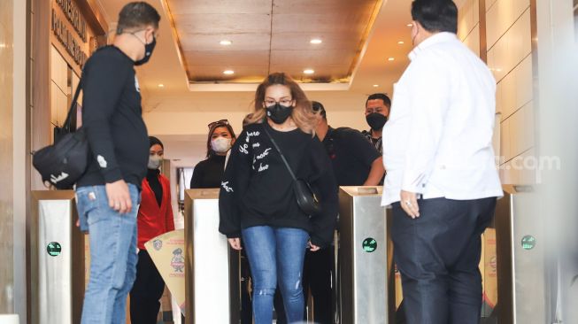 Pedangdut Ayu Ting Ting berjalan keluar usai menjalani pemeriksaan di Polda Metro Jaya, Jakarta Selatan, Selasa (12/11/2021). [Suara.com/Alfian Winanto]