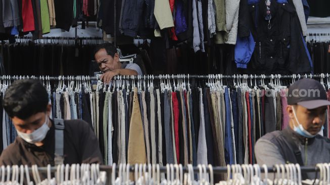 Calon pembeli memilih pakaian bekas layak pakai (thrifting) yang dijual di Pasar Kebayoran Lama, Jakarta, Rabu (13/10/2021). [Suara.com/Angga Budhiyanto]