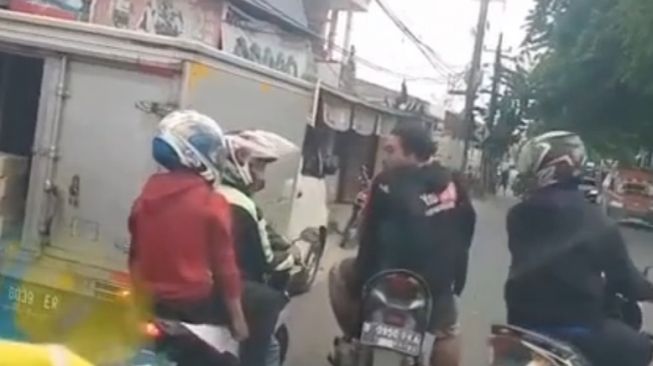 Pria menghentikan pemotor yang sedang mengawal mobil ambulans menuju Cikarang. (Instagram)