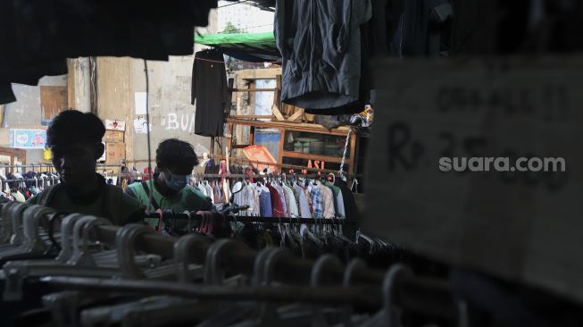 Calon pembeli memilih pakaian bekas layak pakai (thrifting) yang dijual di Pasar Kebayoran Lama, Jakarta, Rabu (13/10/2021). [Suara.com/Angga Budhiyanto]