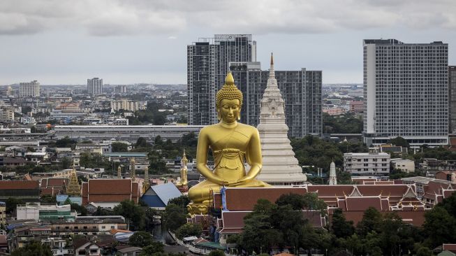 Patung Buddha raksasa setinggi 69 meter berdiri di kuil Wat Paknam Phasi Charoen, Bangkok, pada (12/10/2021). [JACK TAYLOR / AFP]