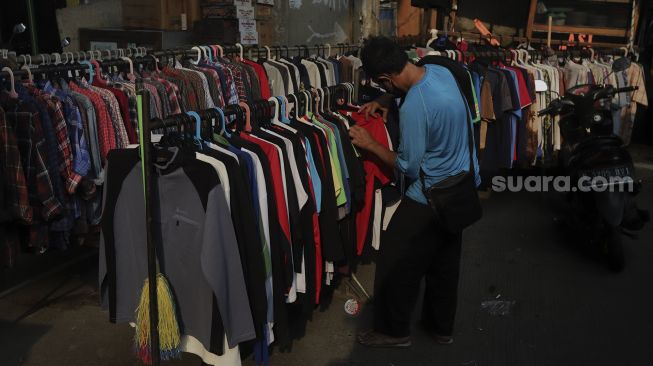 Calon pembeli memilih pakaian bekas layak pakai (thrifting) yang dijual di Pasar Kebayoran Lama, Jakarta, Rabu (13/10/2021). [Suara.com/Angga Budhiyanto]