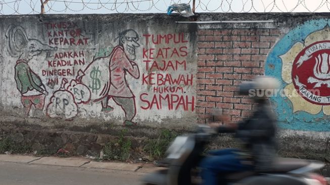 Mural satire 'Keadilan Tumpul Ke Atas Tajam Ke Bawah' yang berada dekat markas Polres Tangsel di Jalan Promoter 3, Kelurahan Lengkong Gudang Timur, Serpong, Rabu (13/10/2021). [SuaraJakarta.id/Wivy Hikmatullah]