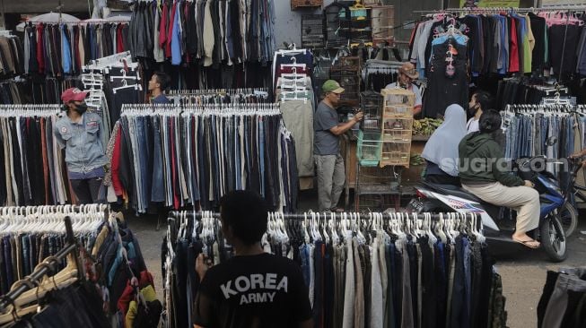 Calon pembeli memilih pakaian bekas layak pakai (thrifting) yang dijual di Pasar Kebayoran Lama, Jakarta, Rabu (13/10/2021). [Suara.com/Angga Budhiyanto]